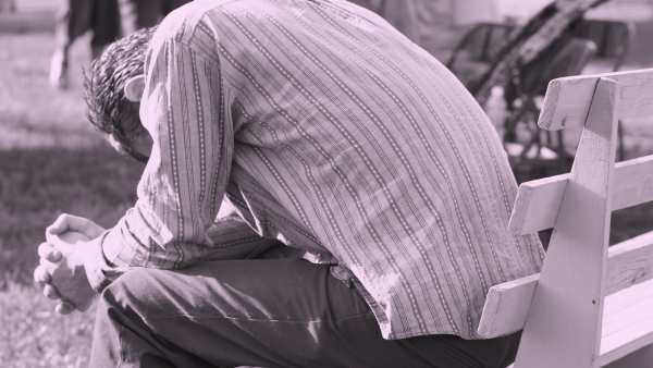 Man bent over praying