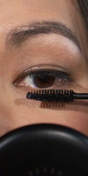 woman putting on mascara