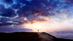 man on a hillside during sunset