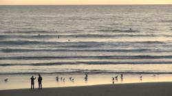 two people standing on a beach