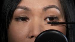 Woman applying makeup to her eye